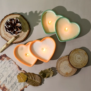 Double heart silicone candle mold with lit green and orange decorative scented candles