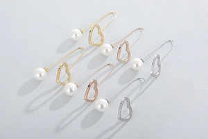 Detailed view of elegant gold and silver heart-shaped pins with pearls and rhinestones