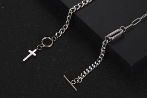 Detailed macro view of silver cross pendant with Cuban and paperclip chain and OT clasp