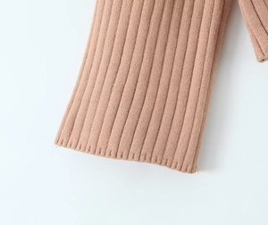 Detail of camel chunky knit sweater cuff showing thick ribbed texture and stitching