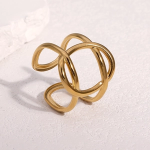 Polished 18k gold plated stainless steel hollow cross ring on white stone background