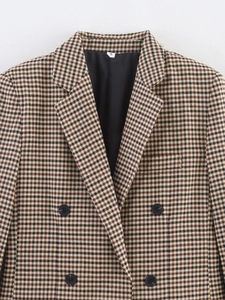 Close-up of brown plaid blazer lapel and buttons showing fabric texture and S size label