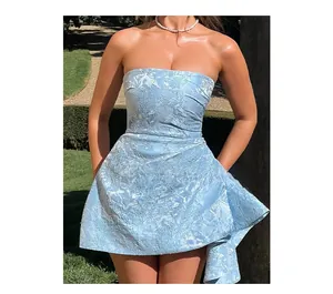 Détail du tissu jacquard bleu clair et de l'ourlet plissé asymétrique de la robe