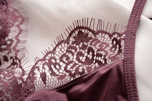 Dettaglio macro del pizzo cigliato e tessuto di seta su lingerie viola scuro
