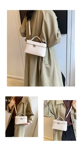 Detailed view of white textured mini crossbody bag with top handle and adjustable strap