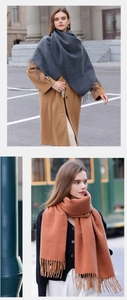 Detail of soft solid color winter scarf with tassels in dark grey and orange brown tones