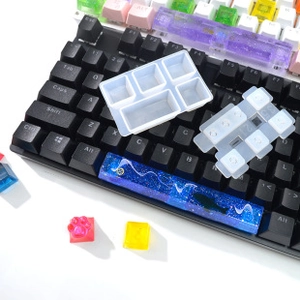 Detailed silicone molds for custom resin keycaps shown on a black mechanical keyboard