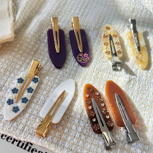 Vue détaillée de 8 barrettes en acétate avec fleurs en résine, strass et motifs lune