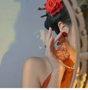 Detail of red rose earrings with long tassels on a model for a vintage Chinese look