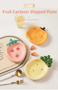 Detail of hand-painted underglaze ceramic fruit plates with strawberry and pineapple textures