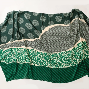 Detailed view of scarf with floral patterns and geometric stripes on soft fabric