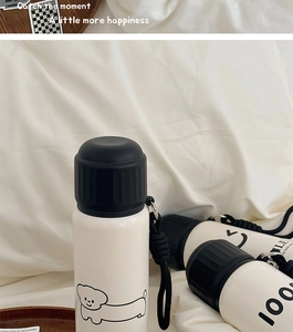 Detail of minimalist white thermos with black lid and cute puppy illustration