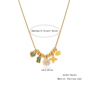 Detail of gold snake chain with heart turquoise, emerald green stone, and white enamel flower