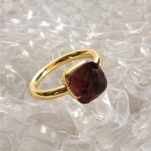 Macro shot of gold square-cut red zircon stone set on a luxury stainless steel ring