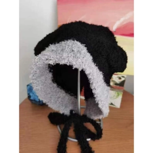 Dettaglio del cappello in maglia con orecchie da orso e lacci lunghi bicolore nero grigio