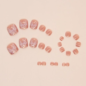 Macro detail of nude pink press-on toenails with white butterfly art and mirror finish
