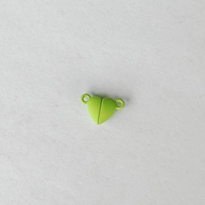 Macro shot of light green heart-shaped magnetic clasp with dual loops for jewelry DIY