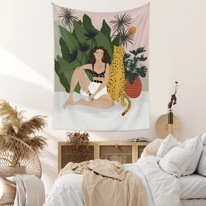 Detail view of Bohemian wall tapestry with jungle illustration above a bedroom bed