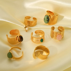 Detailed set of seven vintage gold-plated rings with colorful natural stones on satin