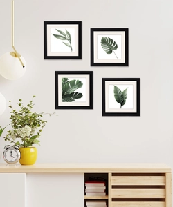 Set of 4 black framed tropical leaf wall art prints in a minimalist Nordic home setting