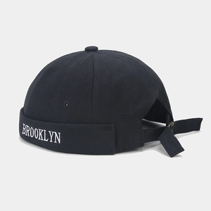 Detail view of Brooklyn embroidery on black canvas docker cap with adjustable strap