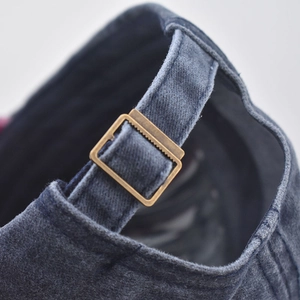 Detail of vintage washed baseball cap showing adjustable metal buckle and cotton texture