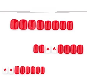 Detail of red and heart-patterned short square press-on nails set on white background