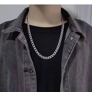 Detailed view of silver Cuban link necklace worn on model for trendy hip-hop street style