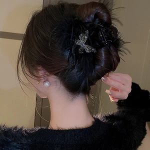 Detail of elegant black down feather butterfly hair claw with sparkling rhinestones decoration