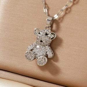 Macro shot of micro-paved teddy bear necklace pendant with clear zircons and bow detail