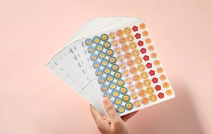 Close-up of hand holding colorful reward stickers with Chinese praise characters