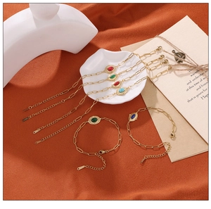 Detail of vintage gold steel bracelets with colorful stones on ceramic props
