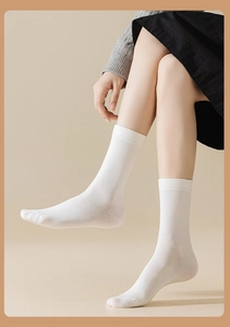 Detailed close-up of ribbed cuffs on pure white combed cotton mid-calf socks for women