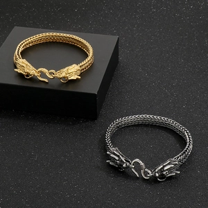 Detailed close-up of vintage stainless steel dragon head bracelets in gold and silver