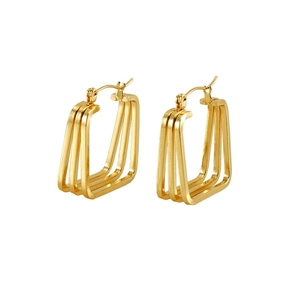 Macro detail of triple-layered geometric gold hoop earrings with polished steel texture