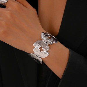 Detail view of silver butterfly cuff bracelet and matching ring with textured metal finish