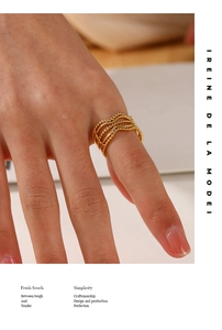 Close-up of golden multi-layer wavy ring with beaded texture worn on a finger