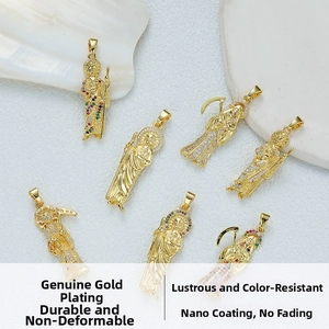 Close-up of religious pendants with colorful stones and gold-plated finish on white sand