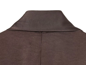 Détail de la robe en satin de soie montrant les coutures du col et le tissu marron foncé