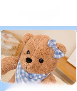 Close-up of brown teddy bear plush with blue checkered scarf and embroidered facial details