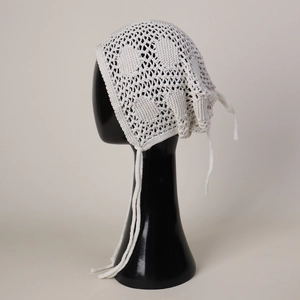 Détail de la charlotte au crochet blanc avec maille ajourée et rubans de serrage fins