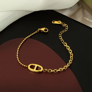 Nahaufnahme des vergoldeten 18K Armbands mit Schweinenasen-Gliedern und asymmetrischer Kette
