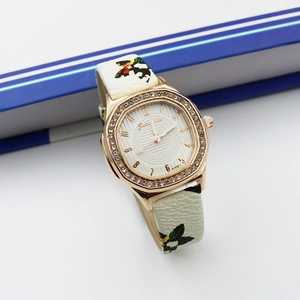 Detail of rose gold octagonal watch case with crystal bezel and floral leather strap
