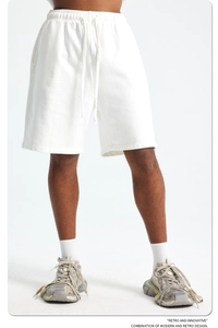 Detail of white cotton sports shorts with drawstring waist and loose fit design