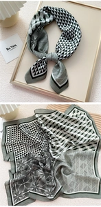 Detail view of a geometric silk scarf with grey-green patterns and vintage textures