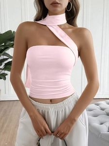 Detail view of pink one-shoulder crop top with neck strap design on a slim-fit silhouette