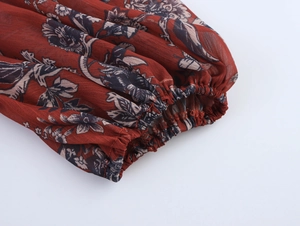 Detail shot of boho floral print dress with elastic wine red cuffs and textured fabric