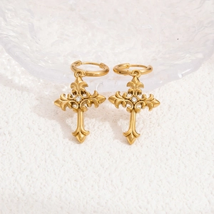 Detailed view of golden cross earrings with fleur-de-lis design and white zircon inlay