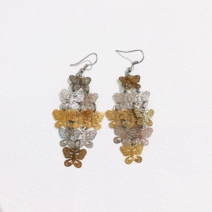 Detailed view of elegant layered butterfly drop earrings with intricate hollow metal design