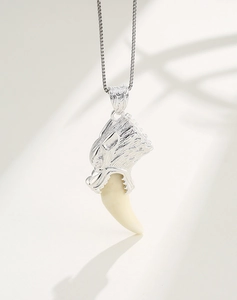 Detail of S925 sterling silver wolf head pendant with white tusk on silver box chain